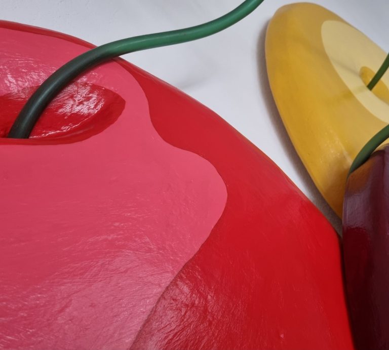 Deux formes arrondies en rouge et jaune avec des fils verts, sur fond blanc.