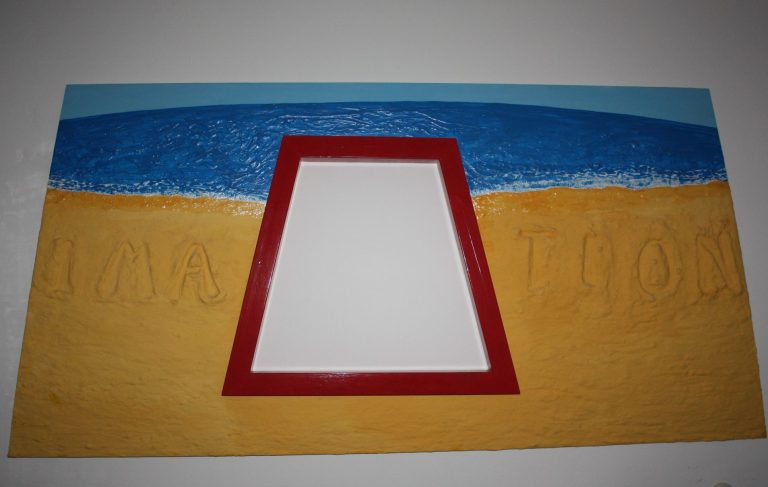 Un cadre rouge sur un fond de plage avec mer et sable.